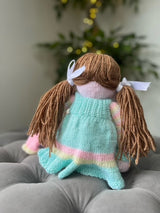 Hand Made Knitted Girl Doll with Brown Hair Blue Dress Holding a Toy Oh So Crafty